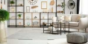 sala de apartamento com mesa quadrada, poltrona e prateleira
