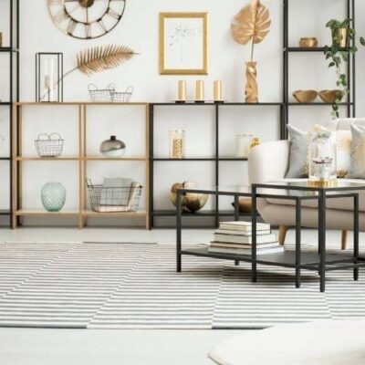 sala de apartamento com mesa quadrada, poltrona e prateleira