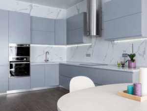 cozinha com uma mesa branca com três velas em cima e armários cinza claro e cinza escuro