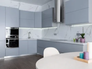 cozinha com uma mesa branca com três velas em cima e armários cinza claro e cinza escuro