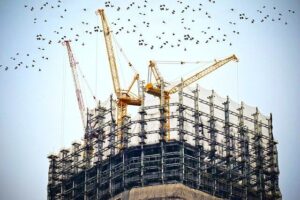 Fachada de um prédio em construção envolto por uma tela de segurança