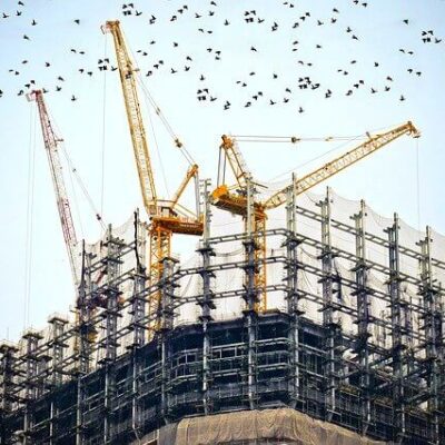 Fachada de um prédio em construção envolto por uma tela de segurança