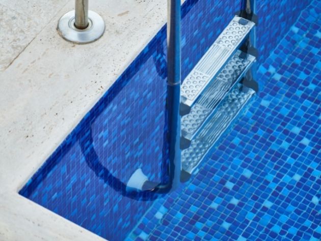 Escada em uma piscina de azulejos azuis