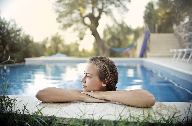 Mulher loira curte piscina com bombas e filtros novos para o verão