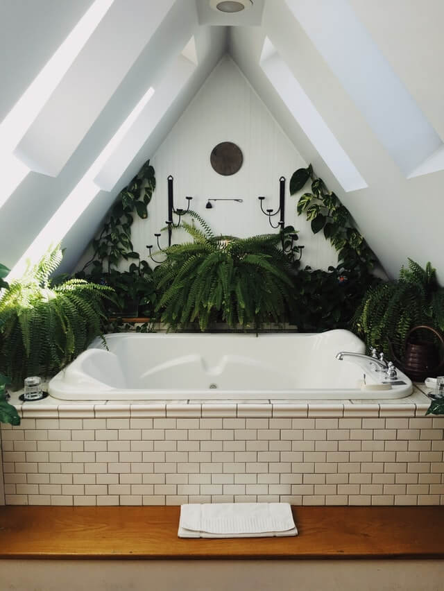 Banheira de hidromassagem em um banheiro cheio de folhas verdes