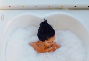 Mulher com cabelo preso aproveita spa em casa na hidro