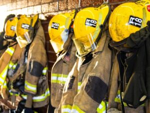 NR 23. Roupas de bombeiros penduradas.