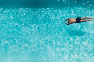 homem mergulhando na piscina
