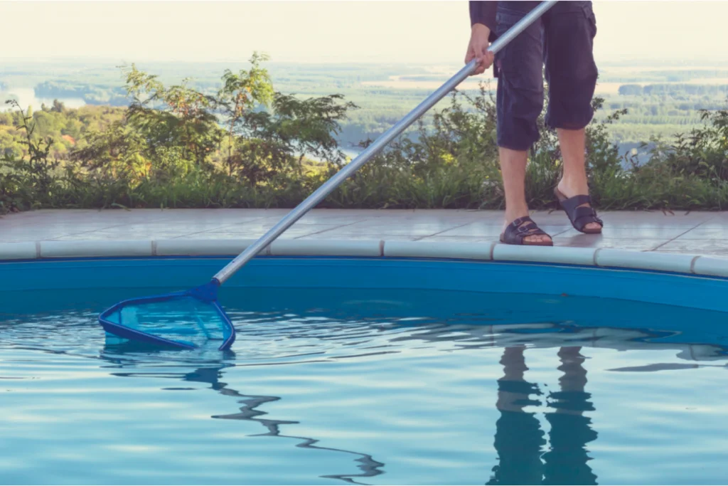 homem limpando a piscina de chinelos